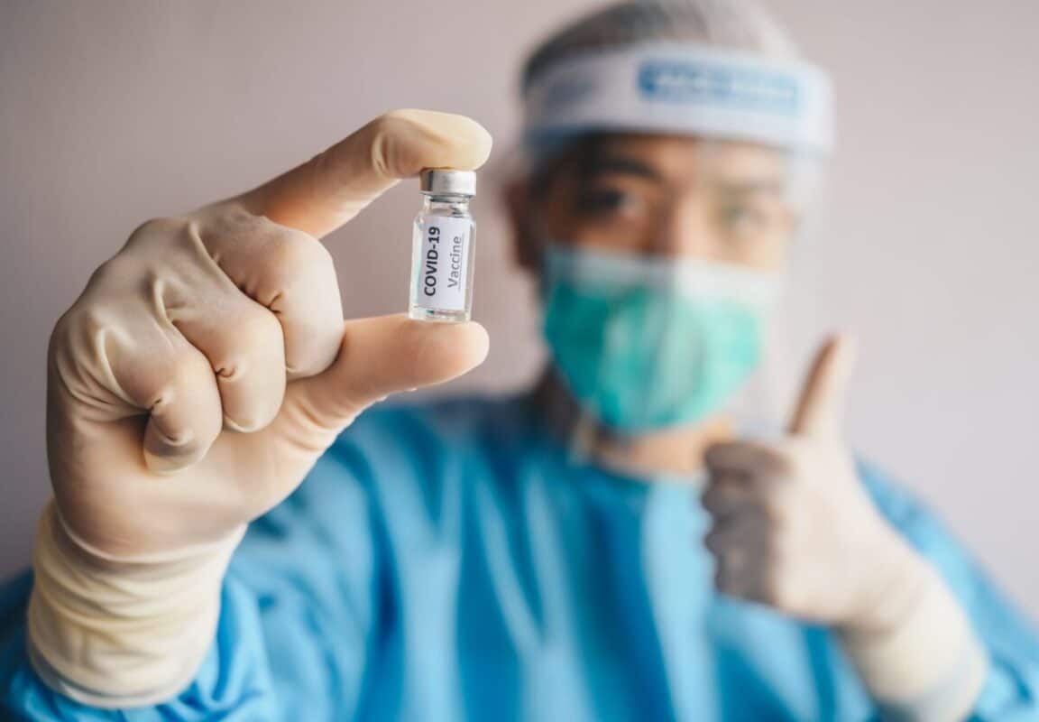 Doctor Holding Covid 19 Vaccine With Thumb Up