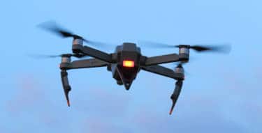 a black spying drone on the evening sky. crime and terrorism theme.
